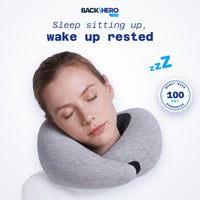 Woman asleep sitting up with her head resting on the gray travel neck pillow