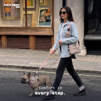 Woman walking a French bulldog in the city on cloud massage insoles – comfort in every step