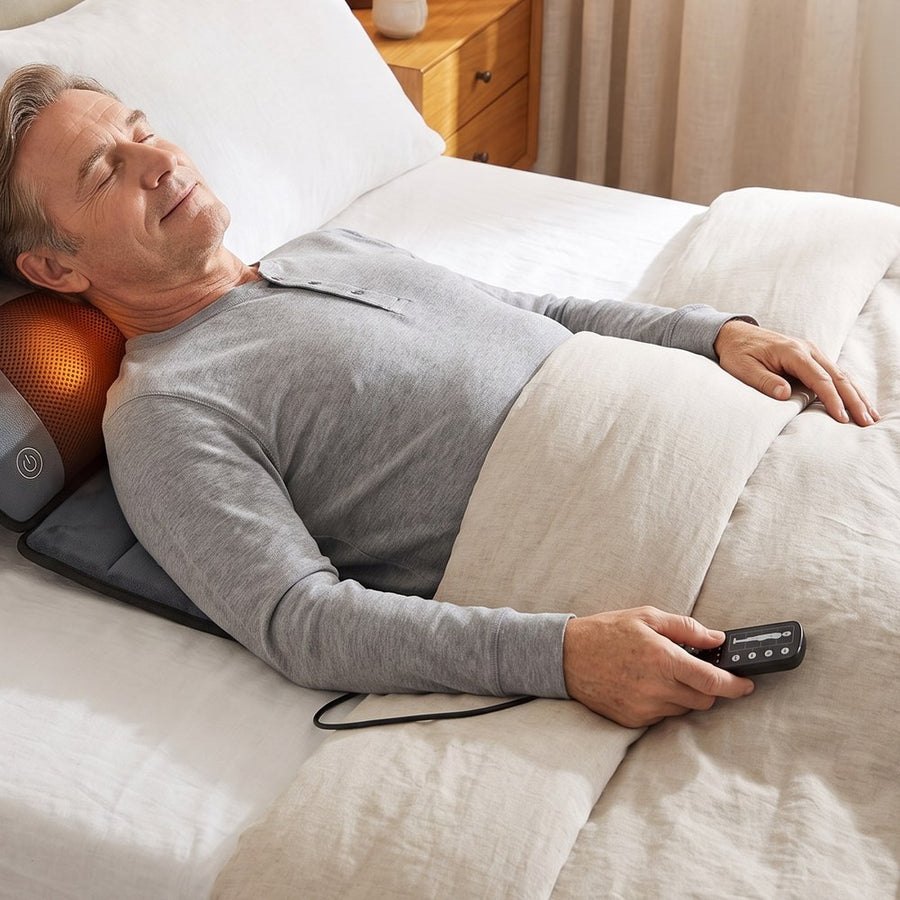 Man relaxing on the massage mat in bed