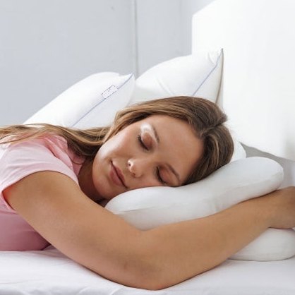 Woman hugging the ergonomic pillow while sleeping